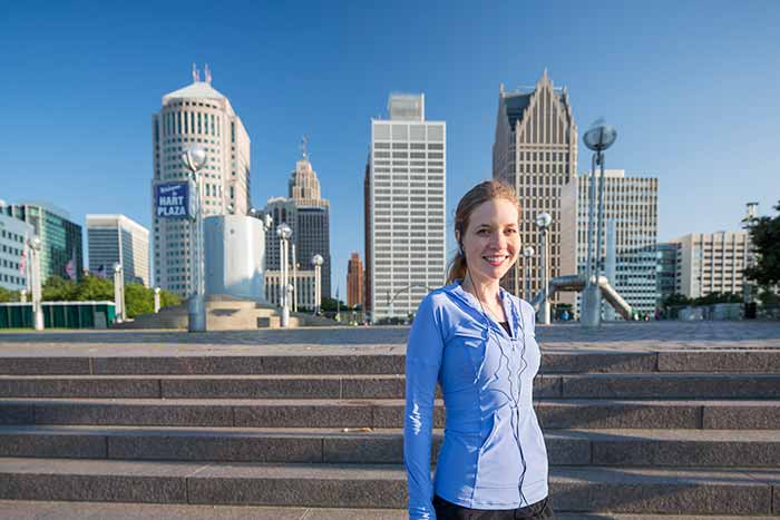 Student up close with Hart Plaza and downtown Detroit in the background