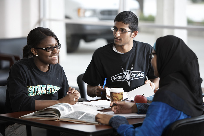 Three Wayne State University students sitting around a table studying together