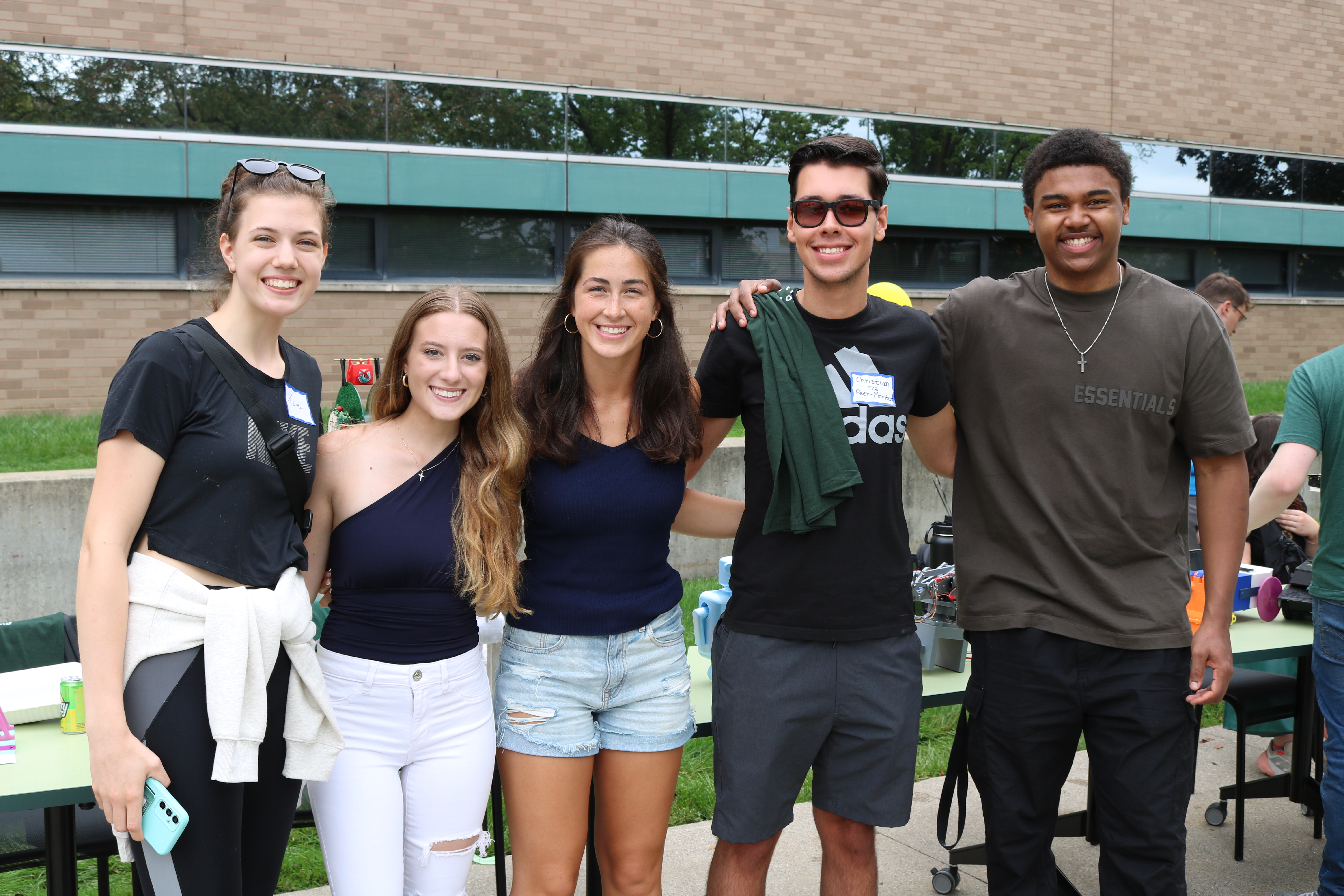 students stand side by side at an on campus event